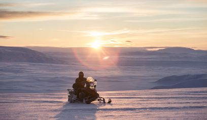 Snowmobiling in Langjökull Glacier in Iceland at sunset